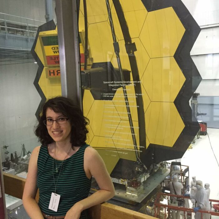 NASA Research Scientist, with the primary mirror of the James Webb Space Telescope